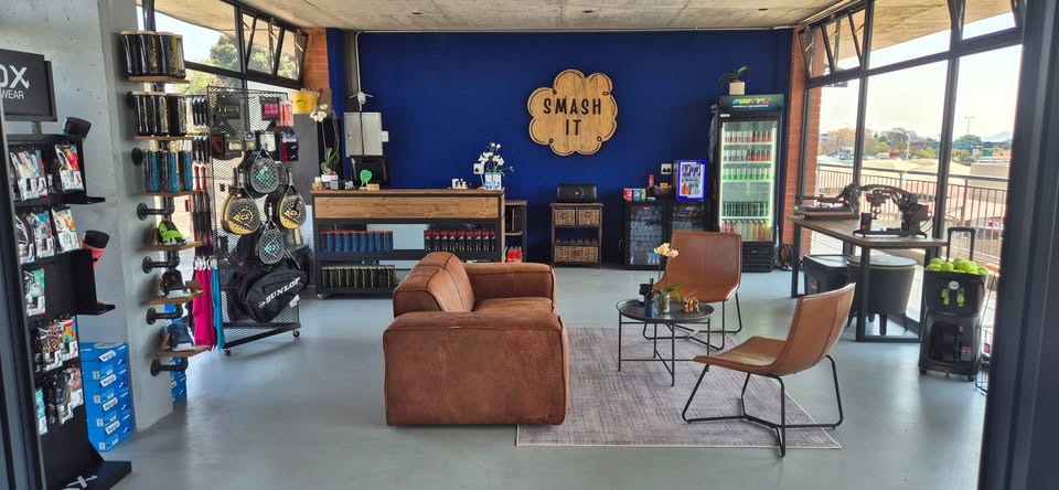 Inside the Smash It shop, with branded signage, padel rackets and apparel displays